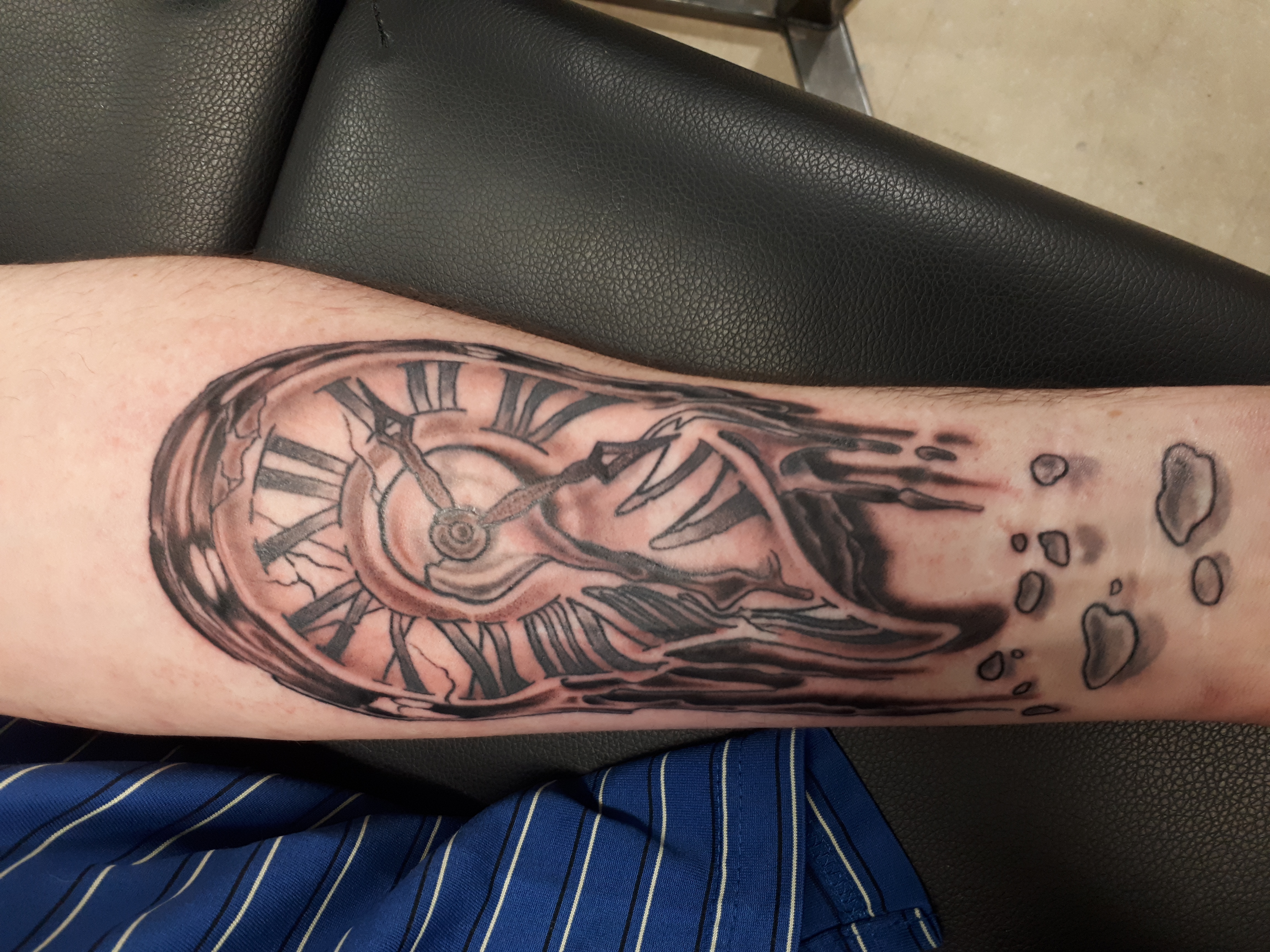 Melting clock tattoo in black and grey