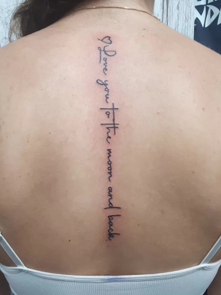 Script tattoo down spine