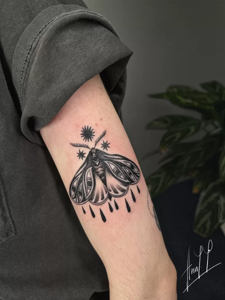 Black and shading moth tattoo on arm