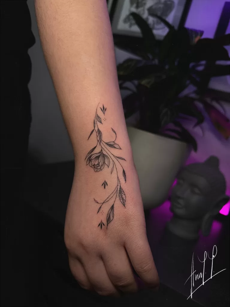 Fineline flower and vines on wrist to hand.