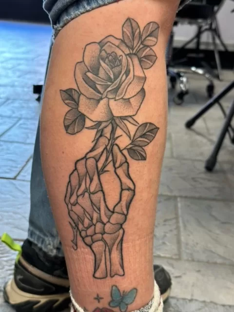 hand holding rose tattoo