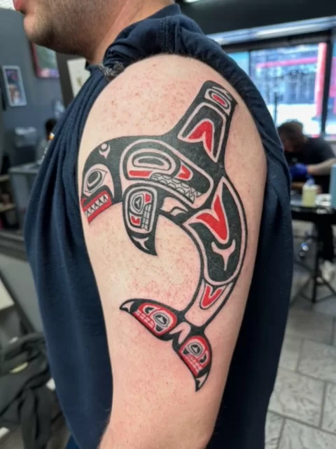 black and red dolphin tattoo